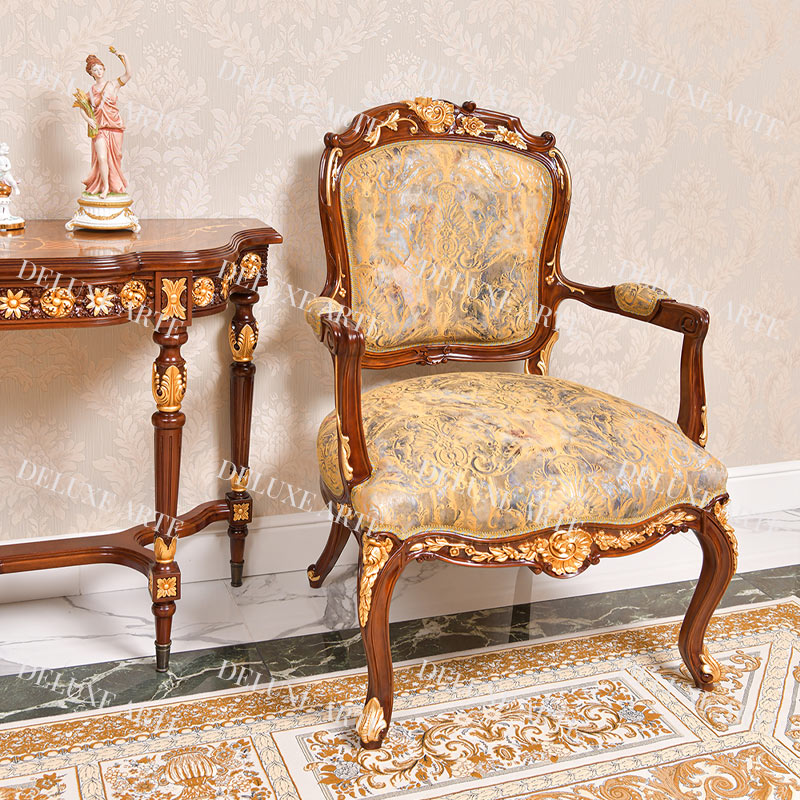 A classic vintage design armchair with natural wood and gold leaf finishing in a gold fabric